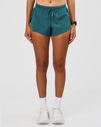 Woman wearing Accelerate 3" Mid-Rise Running Short - Transformative Teal | Set:true | Angle:front | Model:Rhiley | Size:S