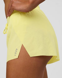 Woman wearing Accelerate 3" Mid-Rise Running Short - Yellow Fizz | Set:true | Angle:closeup | Model:Evie | Size:S
