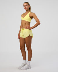 Woman wearing Accelerate 3" Mid-Rise Running Short - Yellow Fizz | Model:Evie | Size:S