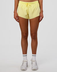 Woman wearing Accelerate 3" Mid-Rise Running Short - Yellow Fizz | Set:true | Angle:front | Model:Evie | Size:S