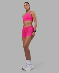 Woman wearing Accelerate 3" Pleated Running Short - Ultra Pink | Model:Rhiley | Size:S