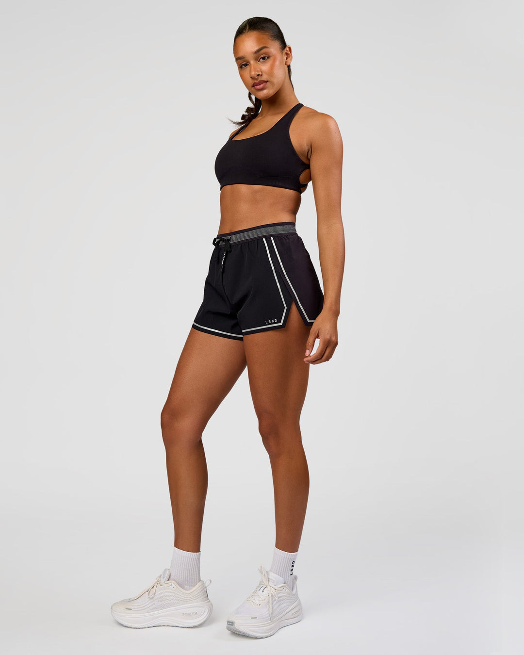 Woman wearing Accelerate 3" Reflective High-Rise Running Short - Black-Reflective | Model:Rosie | Size:S