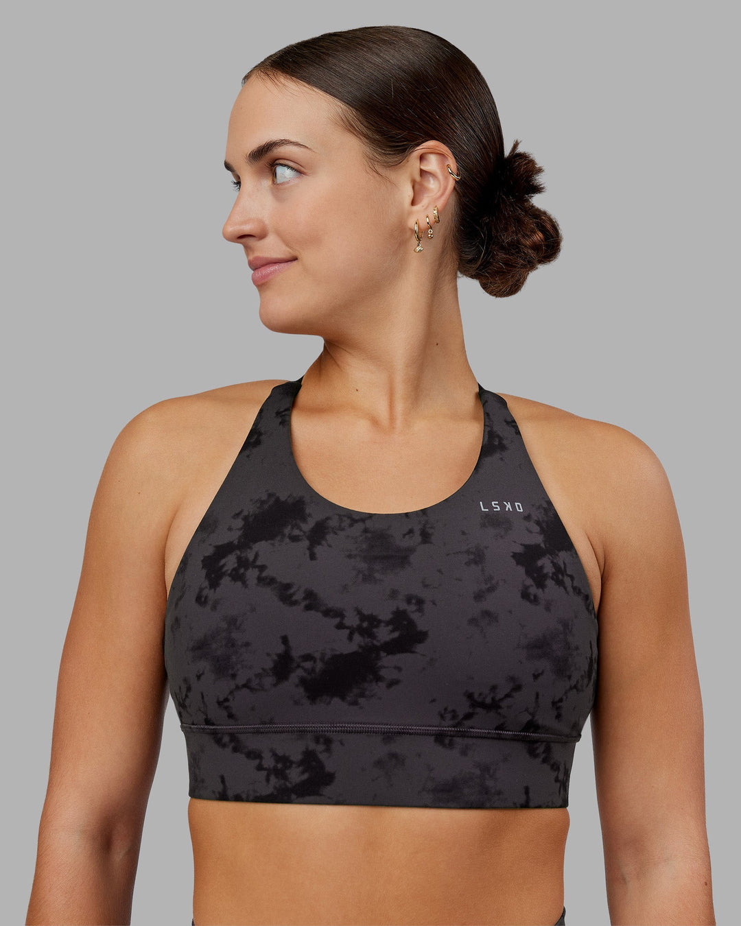 Woman wearing Accelerate Split Strap Sports Bra - Black Tie Dye | Model:Keisha | Size:S