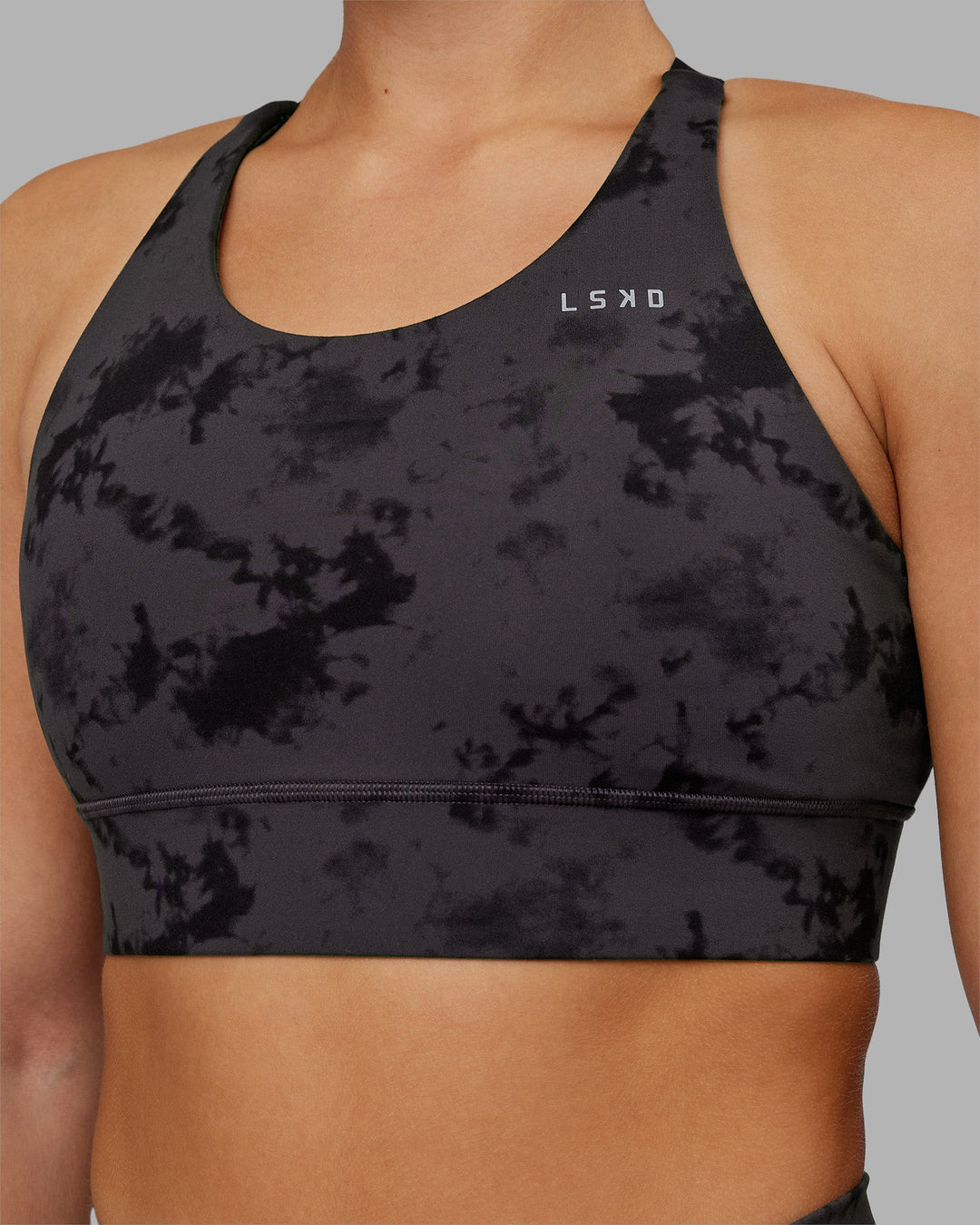 Woman wearing Accelerate Split Strap Sports Bra - Black Tie Dye | Model:Keisha | Size:S