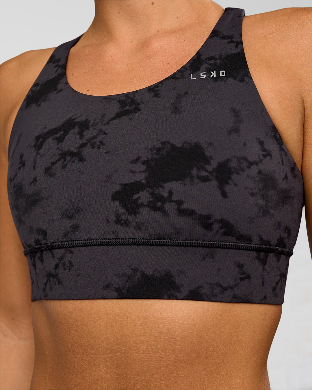 Woman wearing Accelerate Sports Bra - Black Tie Dye | Set:true | Angle:closeup | Model:Amity | Size:S