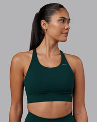 Woman wearing Accelerate Sports Bra - Dark Moss | Set:true | Angle:front | Model:Rhiley | Size:S