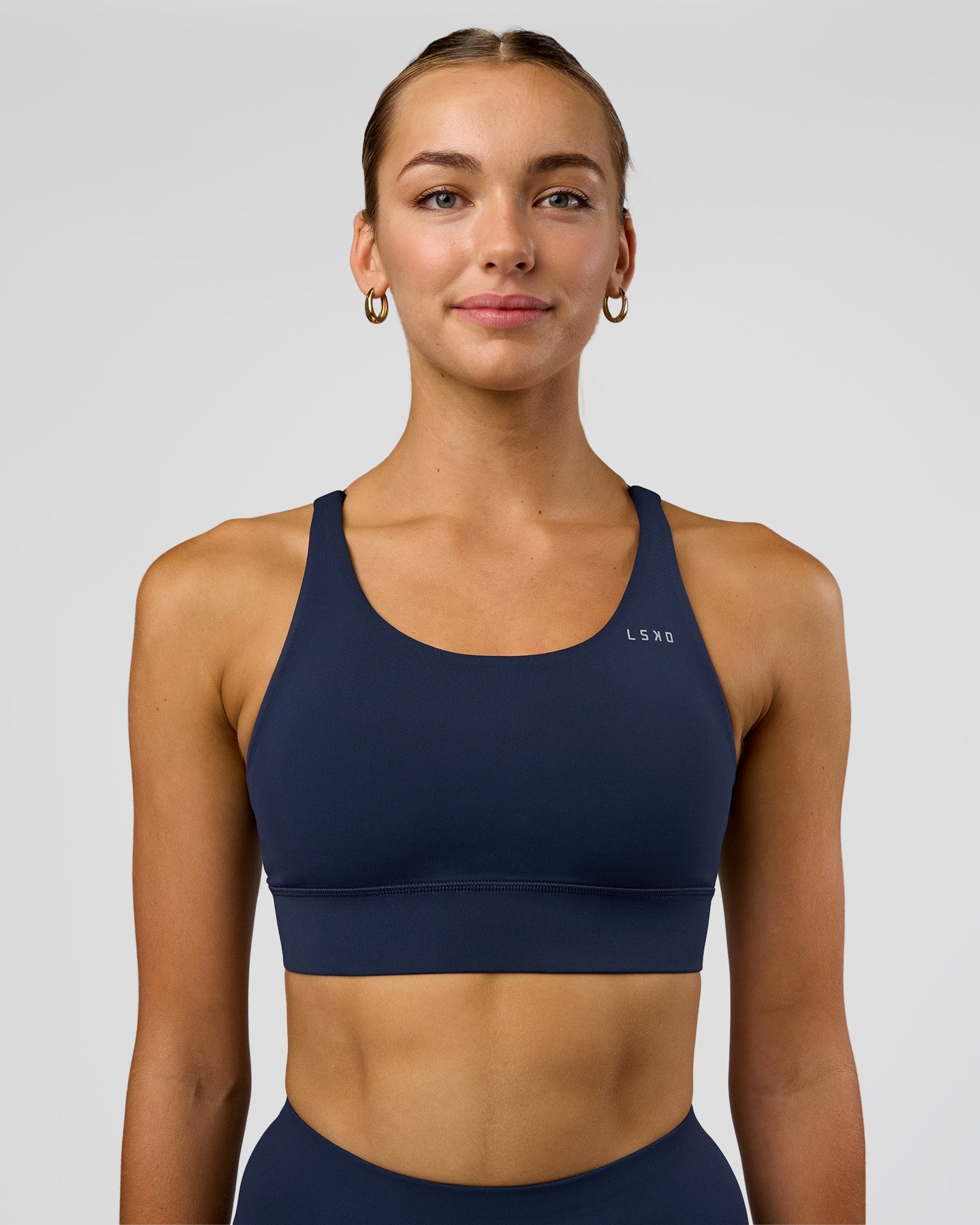 Woman wearing Accelerate Sports Bra - Future Navy | Set:true | Angle:front | Model:Evie | Size:S