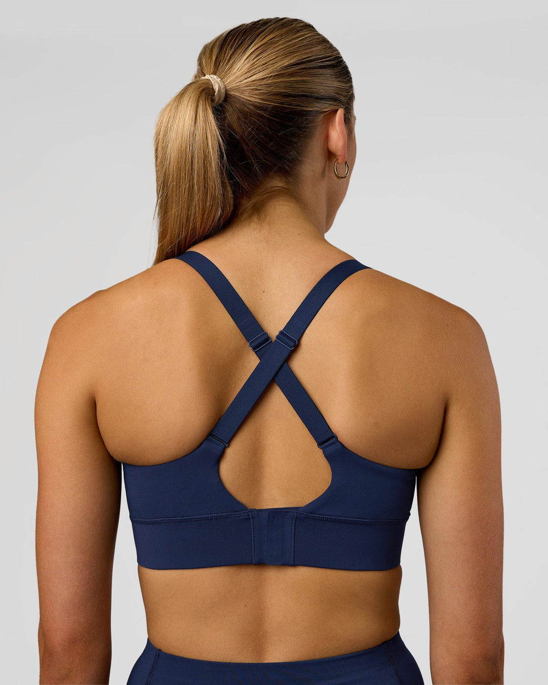 Woman wearing Accelerate Sports Bra - Future Navy | Set:true | Angle:back | Model:Evie | Size:S