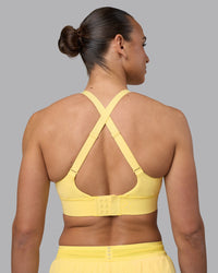 Woman wearing Accelerate Sports Bra - Lemon | Set:true | Angle:back | Model:Sophie | Size:S