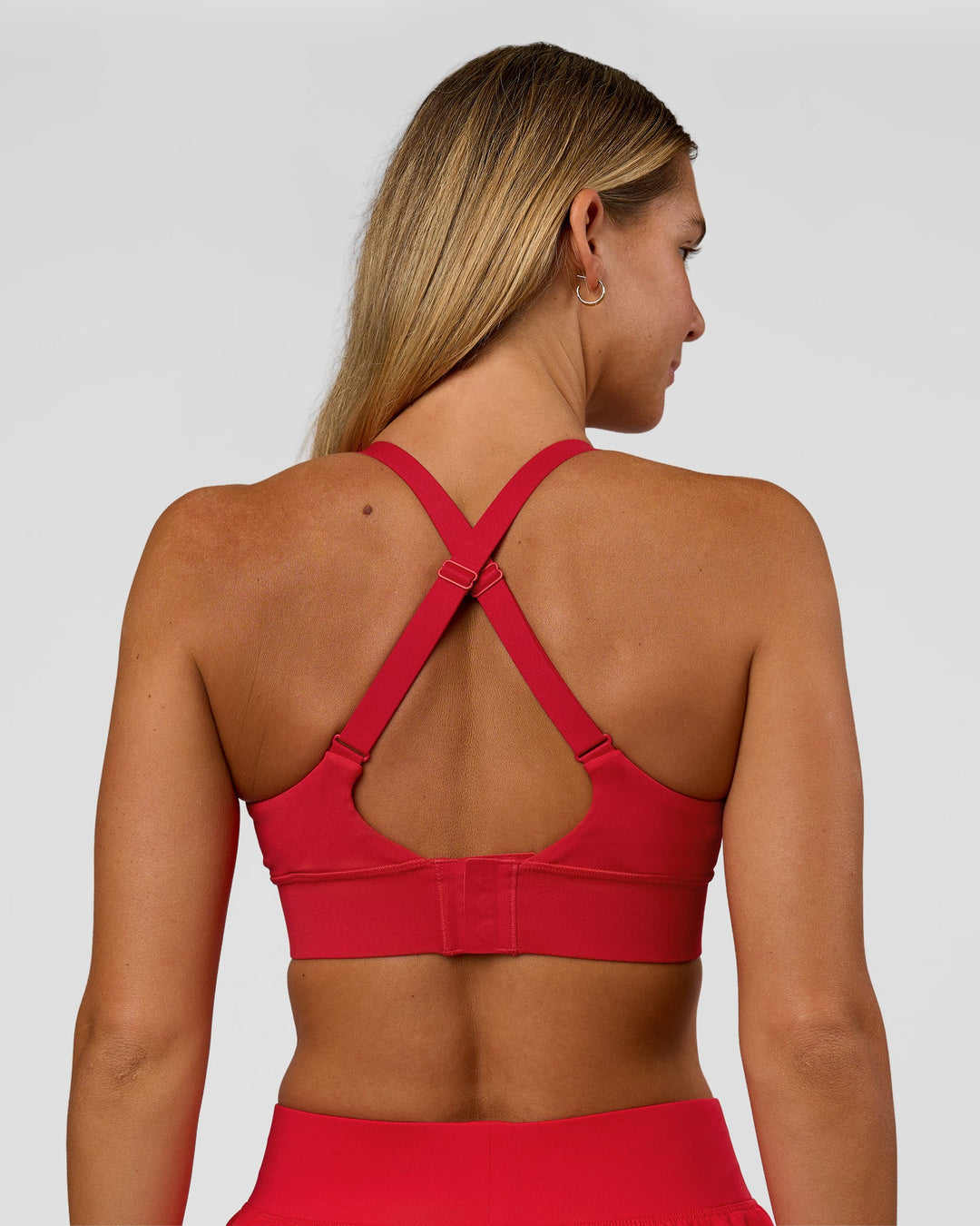 Woman wearing Accelerate Sports Bra - Scarlet | Set:true | Angle:back | Model:Amity | Size:S