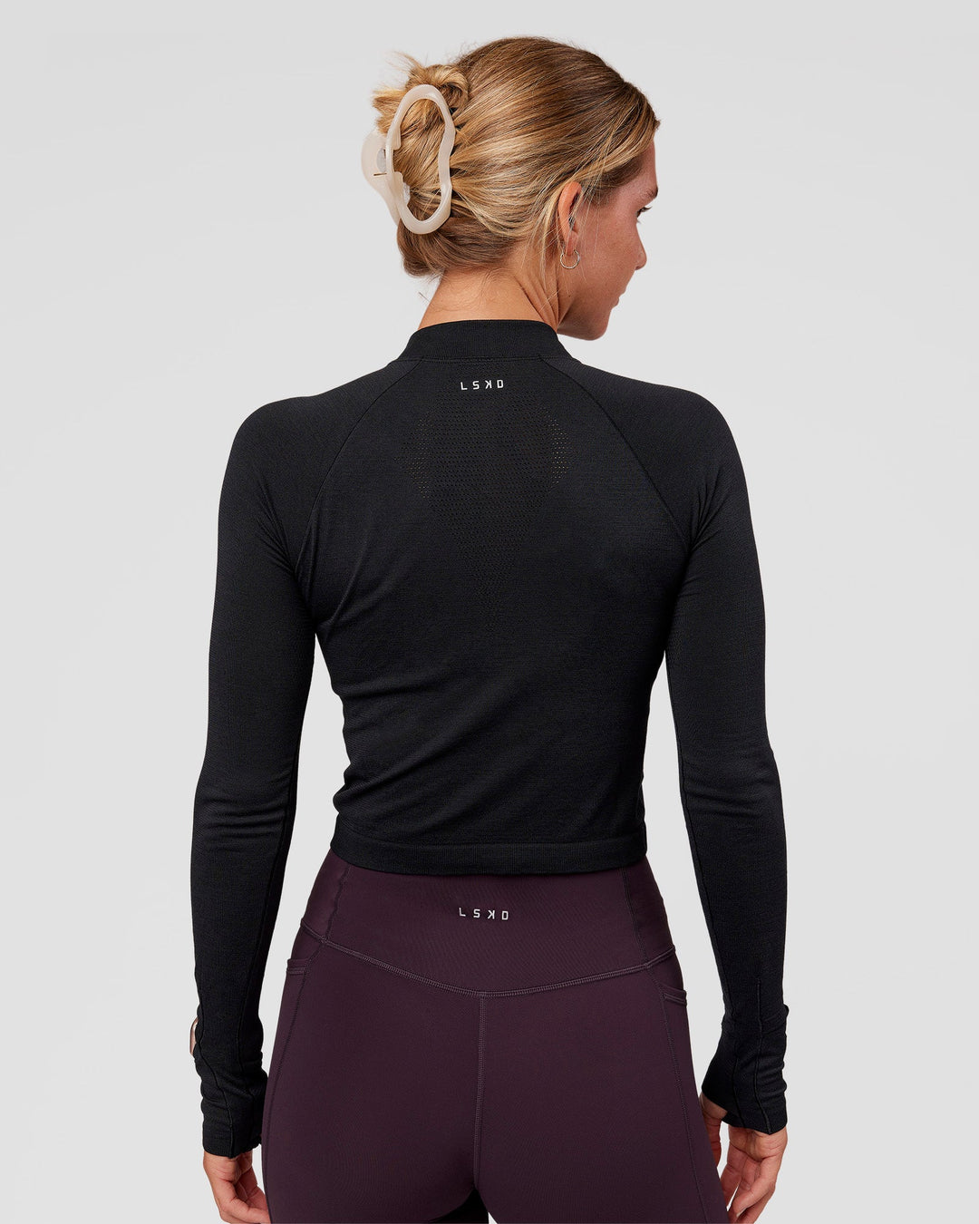 Woman wearing AeroFLX+ Long Sleeve Skimmer Half Zip - Black Marl | Model:Amity | Size:S
