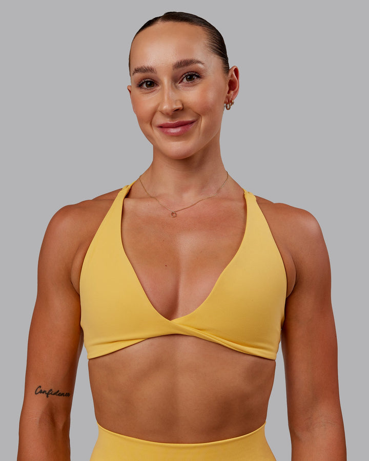 Woman wearing Agile Sports Bra in Banana Cream | Size:S
