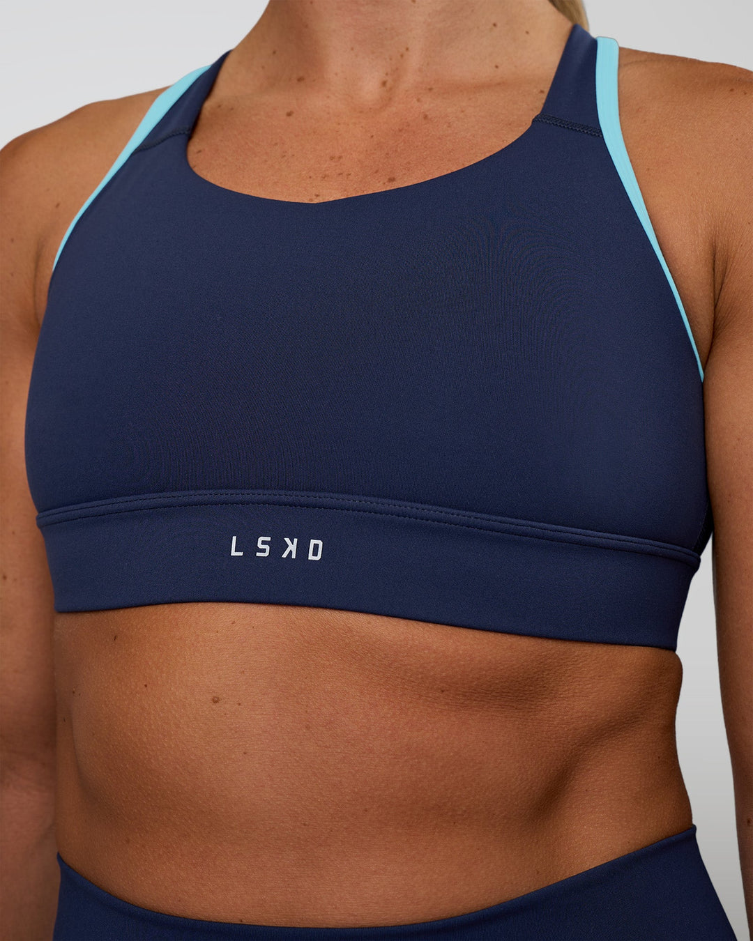 Woman wearing Distinction Sports Bra 2.0 - Future Navy-Baltic Sea | Model:Sav | Size:S