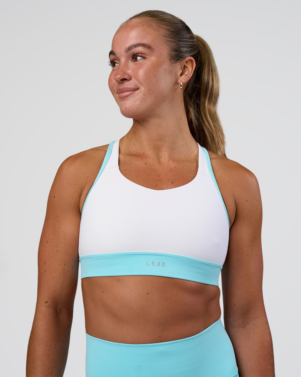 Woman wearing Distinction Sports Bra 2.0 - White-Baltic Sea | Model:Sav | Size:S - view 1