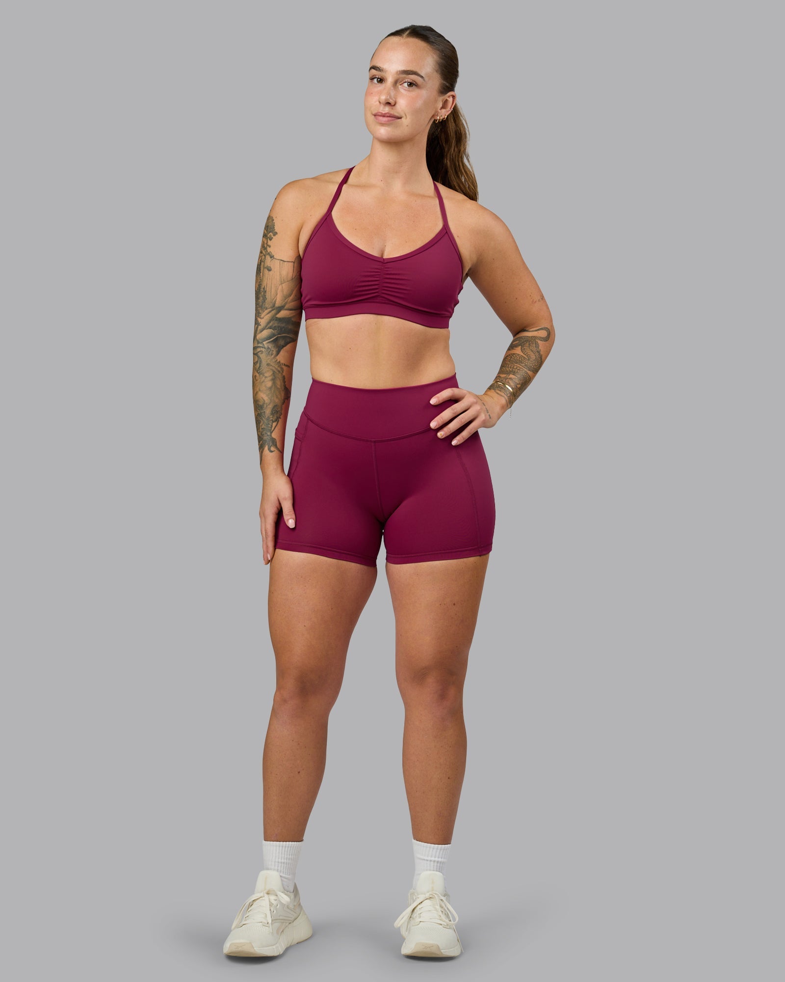Woman wearing Elite High-Rise 4" Short Pockets - Plum Berry | Model:Robyn | Size:S