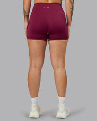 Woman wearing Elite High-Rise 4" Short Pockets - Plum Berry | Model:Robyn | Size:S