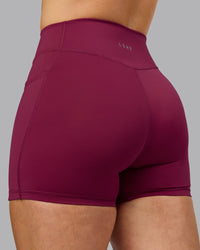 Woman wearing Elite High-Rise 4" Short Pockets - Plum Berry | Model:Robyn | Size:S