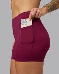 Woman wearing Elite High-Rise 4" Short Pockets - Plum Berry | Model:Robyn | Size:S