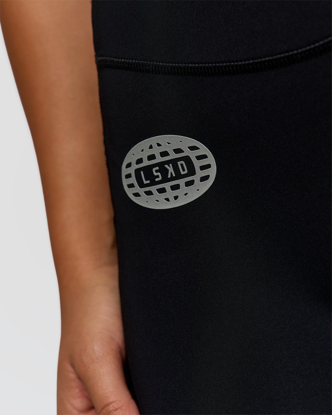 Woman wearing Elite Hype Reflective Run High-Rise 7" Short Pockets - Black-Hype Reflective | Model:Sophia | Size:S
