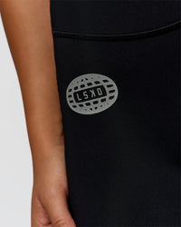 Woman wearing Elite Hype Reflective Run High-Rise 7" Short Pockets - Black-Hype Reflective | Model:Sophia | Size:S