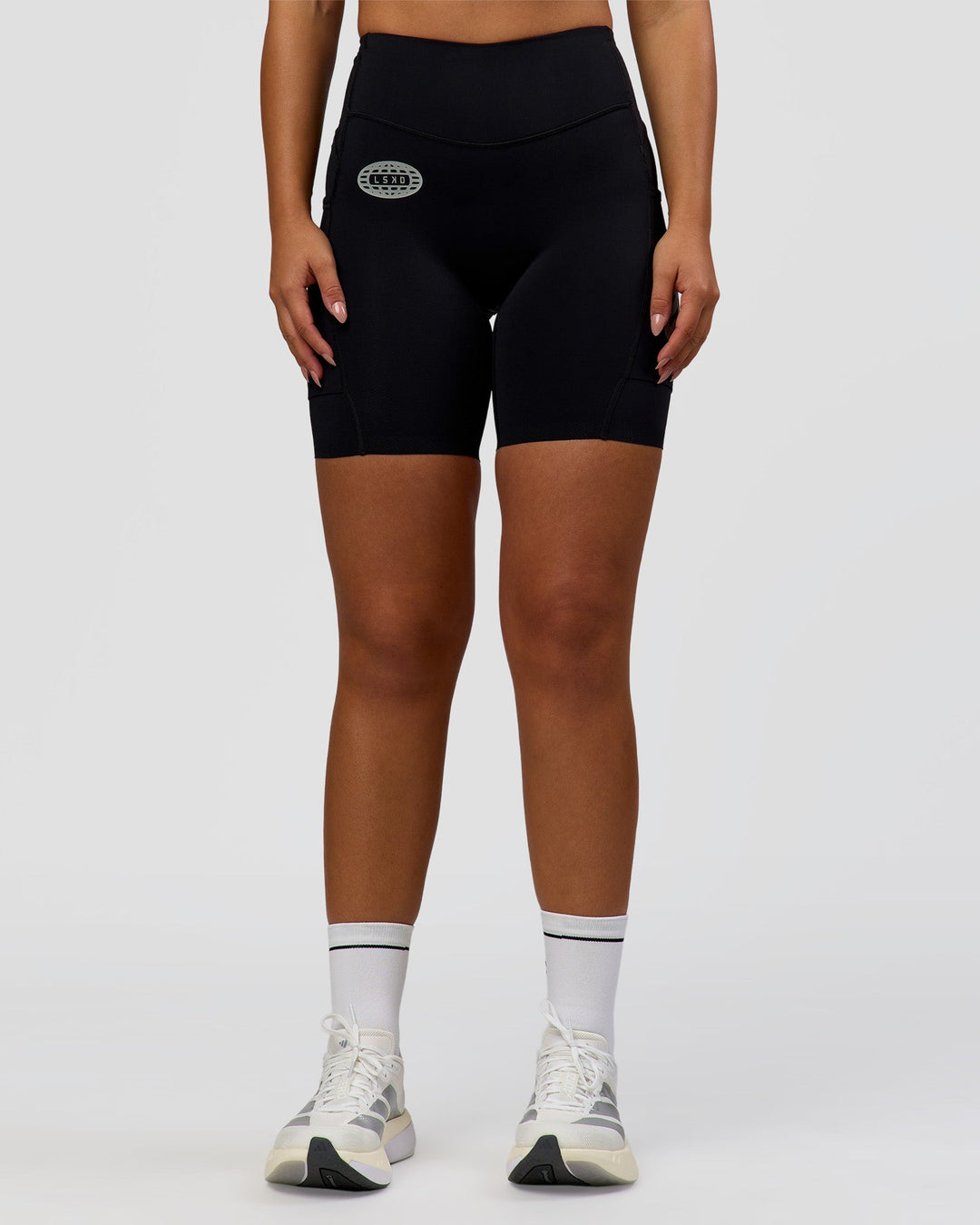Woman wearing Elite Hype Reflective Run High-Rise 7" Short Pockets - Black-Hype Reflective | Model:Sophia | Size:S