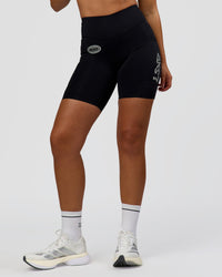 Woman wearing Elite Hype Reflective Run High-Rise 7" Short Pockets - Black-Hype Reflective | Model:Sophia | Size:S
