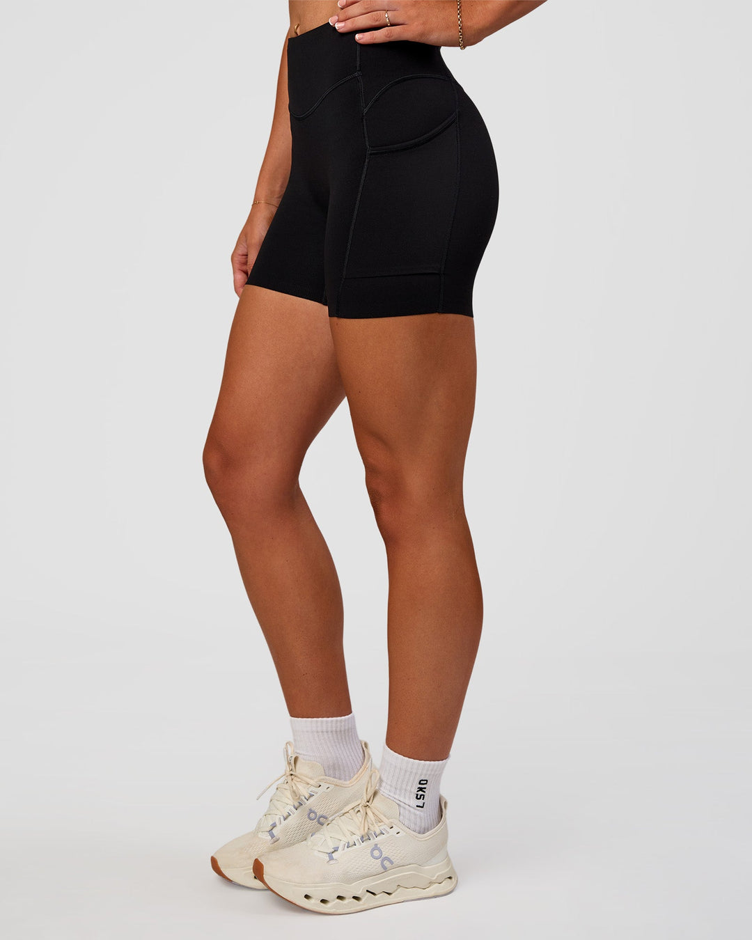 Woman wearing Elite Run High-Rise 5" Short Pockets - Black | Model:Emelia | Size:S