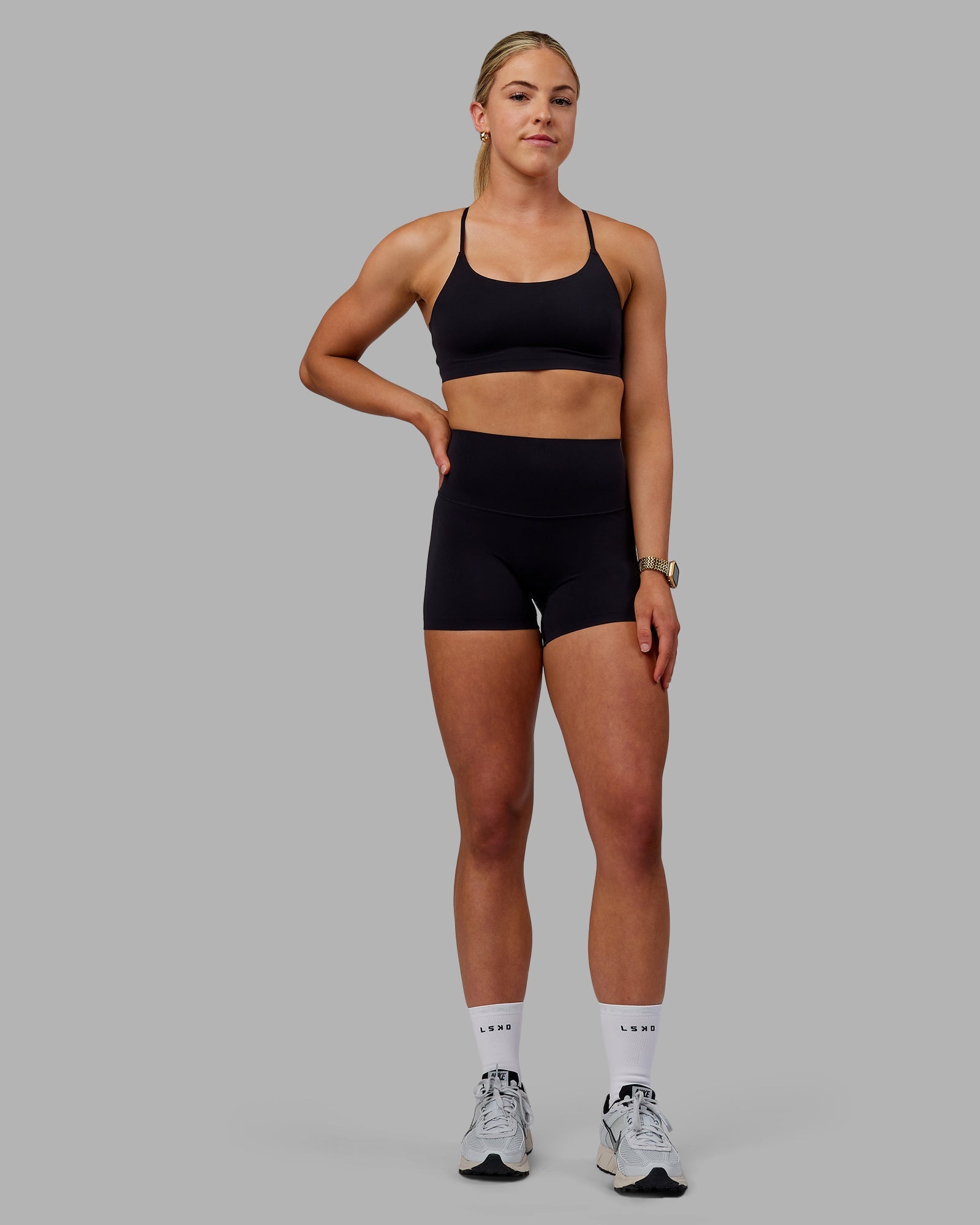 Woman wearing Elixir Ultra High-Rise Bonded Waistband 4" Short - Black | Model:Caitlin | Size:S