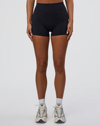 Woman wearing Elixir Defined High-Rise 4" Short Pockets - Black | Model:Bianca | Size:S