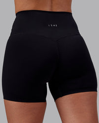 Woman wearing Elixir High-Rise 6" Short - Black | Model:Rhiley | Size:S