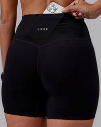 Woman wearing Elixir High-Rise 6" Short - Black | Model:Rhiley | Size:S