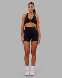 Woman wearing Elixir Ultra High-Rise 4" Short Pockets - Black | Model:Kirstyn | Size:S