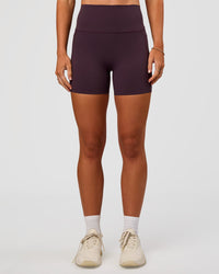 Woman wearing Elixir Ultra High-Rise 4" Short Pockets - Midnight Plum | Model:Emelia | Size:S