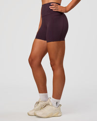 Woman wearing Elixir Ultra High-Rise 4" Short Pockets - Midnight Plum | Model:Emelia | Size:S