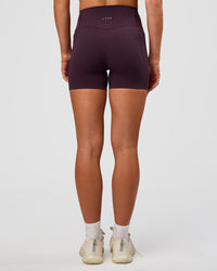 Woman wearing Elixir Ultra High-Rise 4" Short Pockets - Midnight Plum | Model:Emelia | Size:S