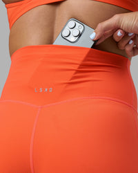 Woman wearing Elixir Ultra High-Rise 4" Short - Ultra Orange | Model:Katie | Size:S