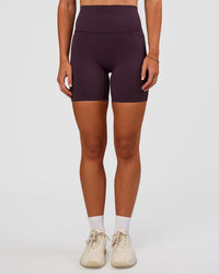 Woman wearing Elixir Ultra High-Rise 6” Short Pockets - Midnight Plum | Model:Emelia | Size:S