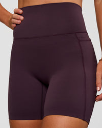 Woman wearing Elixir Ultra High-Rise 6” Short Pockets - Midnight Plum | Model:Emelia | Size:S