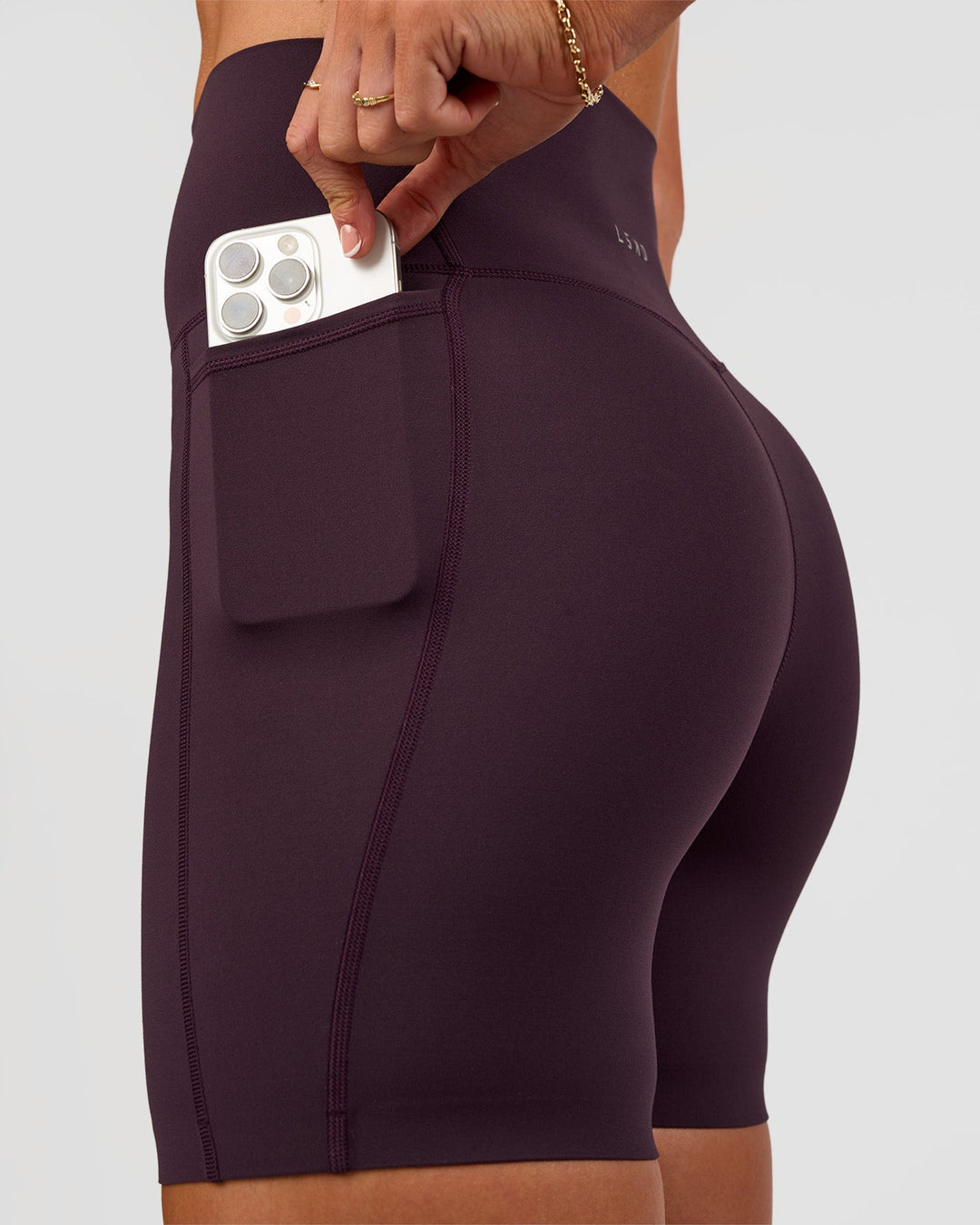 Woman wearing Elixir Ultra High-Rise 6” Short Pockets - Midnight Plum | Model:Emelia | Size:S