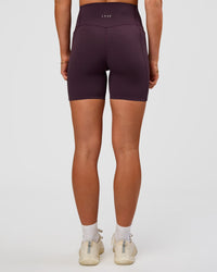 Woman wearing Elixir Ultra High-Rise 6” Short Pockets - Midnight Plum | Model:Emelia | Size:S