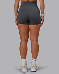 Woman wearing Elixir Ultra High-Rise 4" Short Pockets in Dark Storm | Size:S