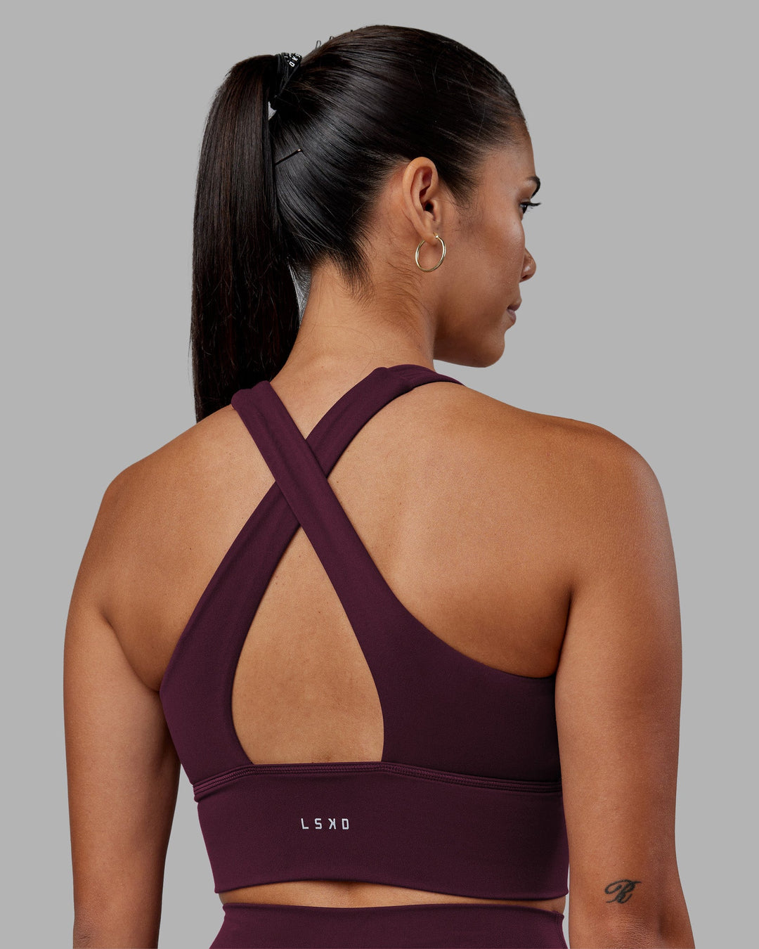 Woman wearing Evoke Longline Sports Bra - Cherry Lacquer | Model:Rhiley | Size:S