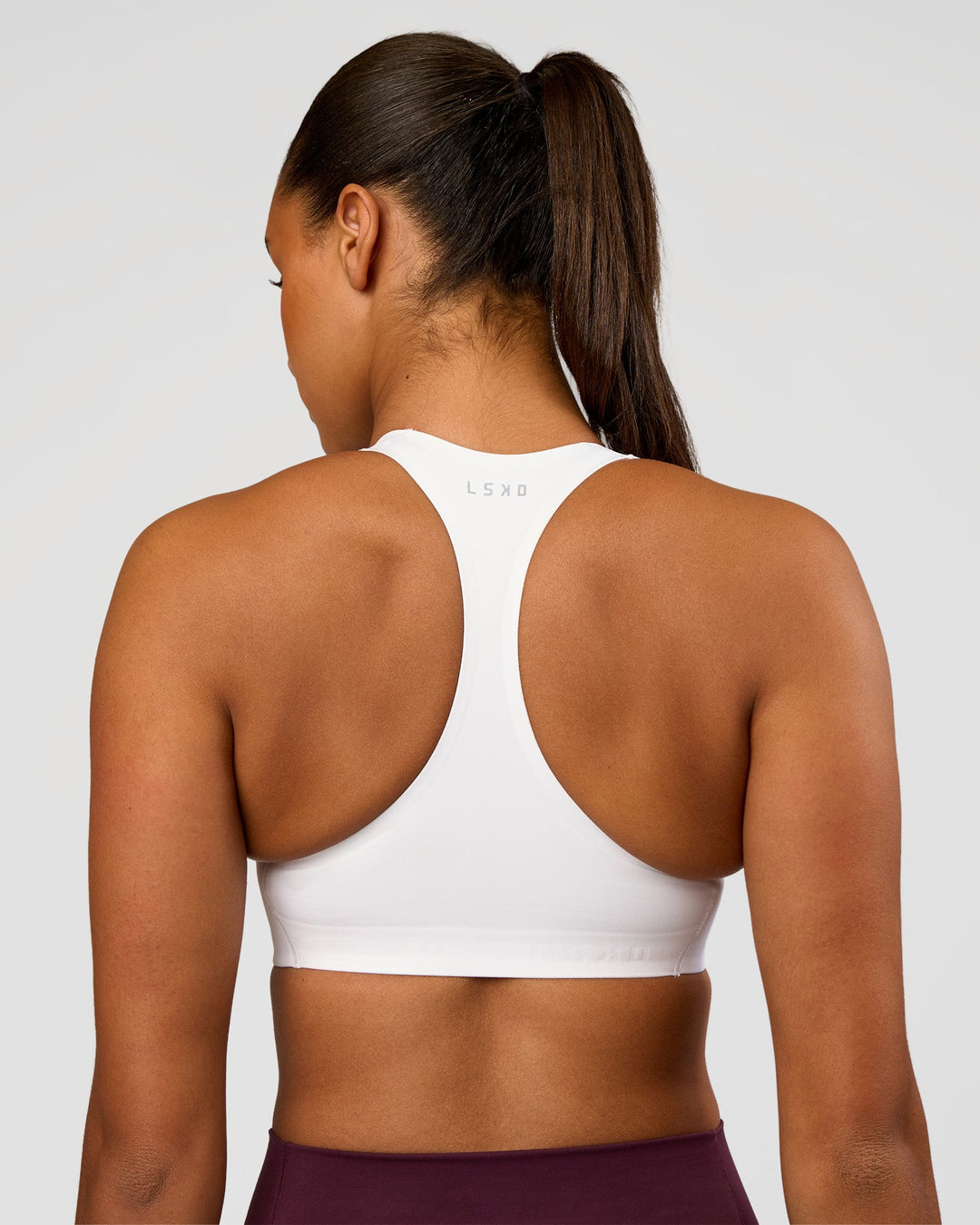 Woman wearing Flow Bonded Scoop Neck Sports Bra - White | Model:Rosie | Size:S
