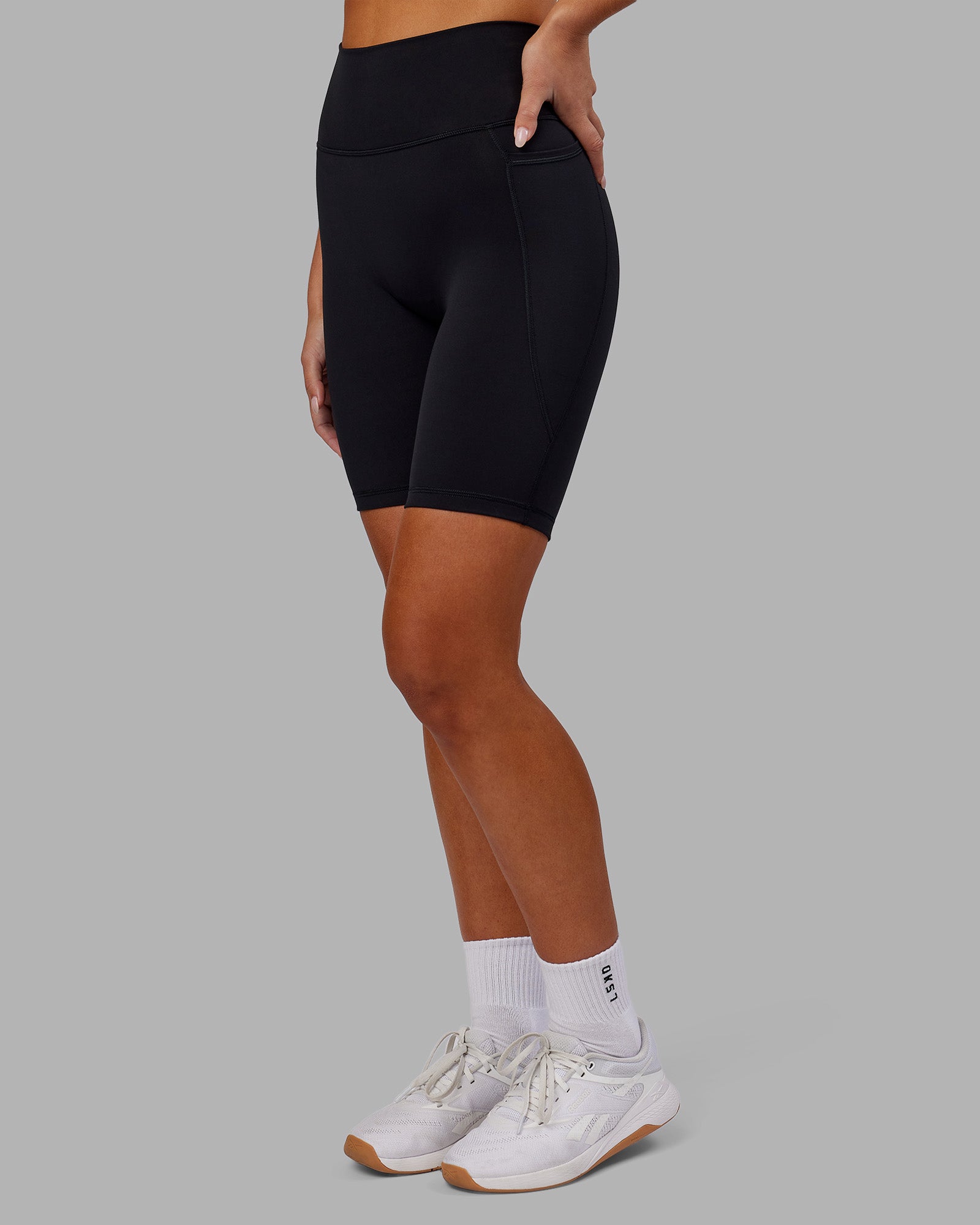 Woman wearing Fusion Ultra High-Rise 9" Short Pockets - Black | Model:Kirstyn | Size:S