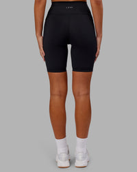 Woman wearing Fusion Ultra High-Rise 9" Short Pockets - Black | Model:Kirstyn | Size:S