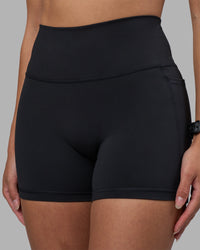 Woman wearing Fusion High-Rise 4" Short Pockets - Black | Model:Rhiley | Size:S