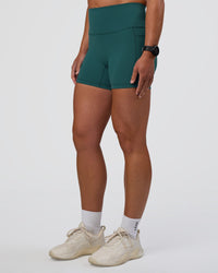 Woman wearing Fusion High-Rise 4" Short Pockets - Transformative Teal | Model:Sav | Size:S
