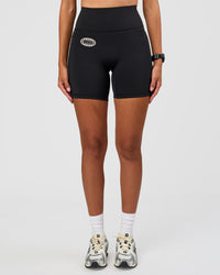 Woman wearing Fusion Hype Graphic Ultra High-Rise 6" Short Pockets - Black-Alloy | Model:Rhiley | Size:S