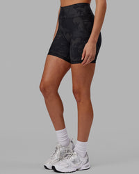 Woman wearing Fusion Ultra High-Rise 6" Short Pockets - Black Camo | Set:true | Angle:side | Model:Katie | Size:S