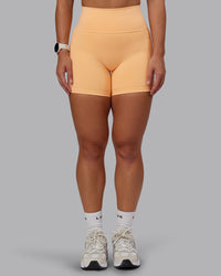 Woman wearing Fusion Ultra High-Rise 6" Short Pockets - Peach Fuzz | Model:Lyss | Size:S